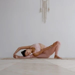 Девушка в розовом занимается йогой